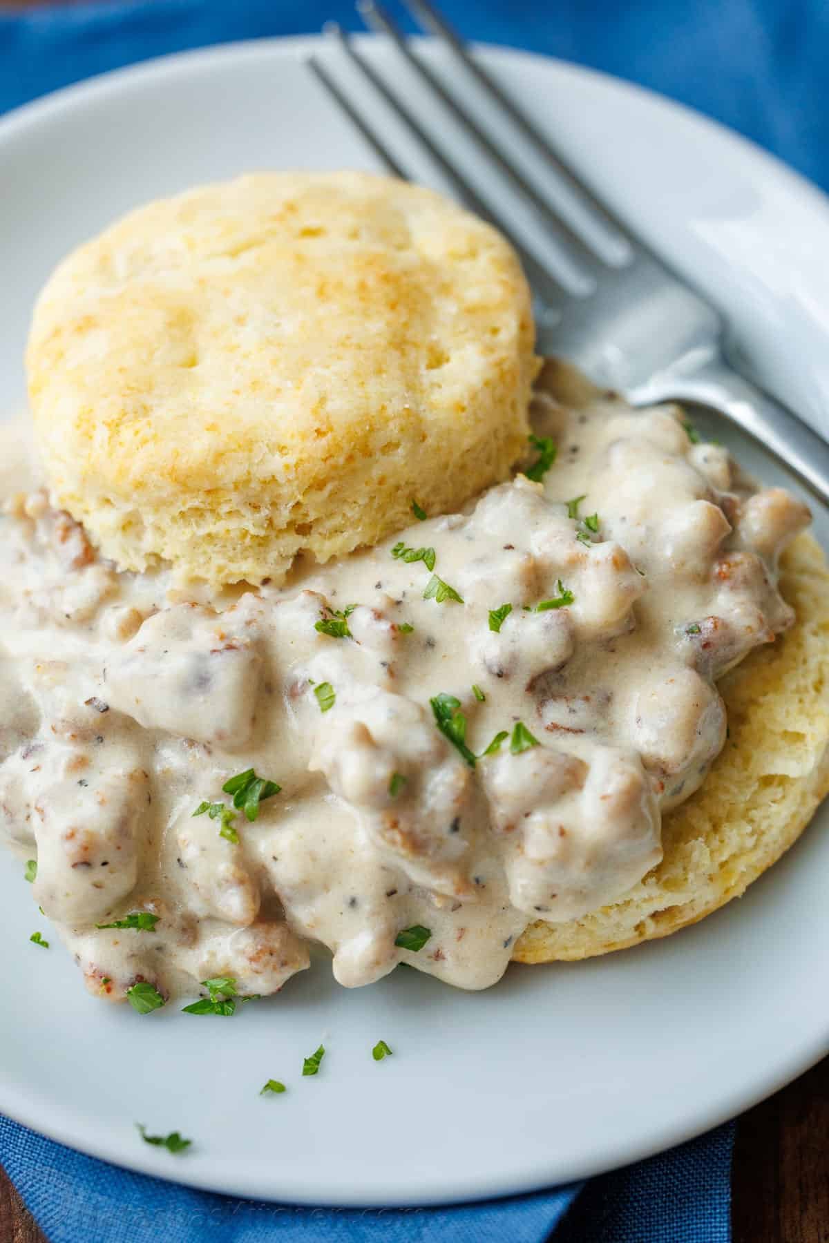 Close up of homemade biscuits and gravy on a plate with a fork