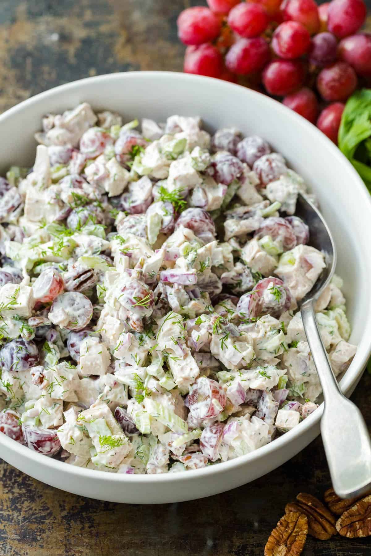 Easy Chicken Salad with chicken, grapes, pecans, and the best creamy dressing. A fresher and lightened-up version of classic chicken salad. Chicken salad in mixing bowl garnished with dill