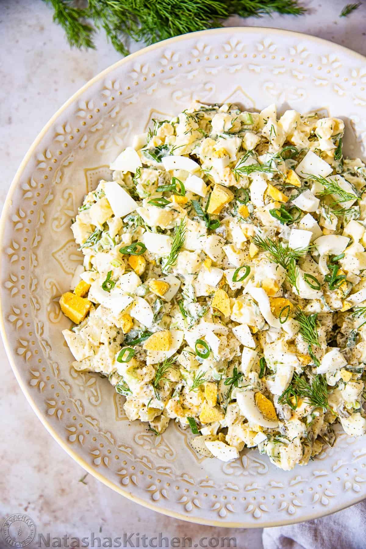 Potato salad sprinkled with dill in beige bowl