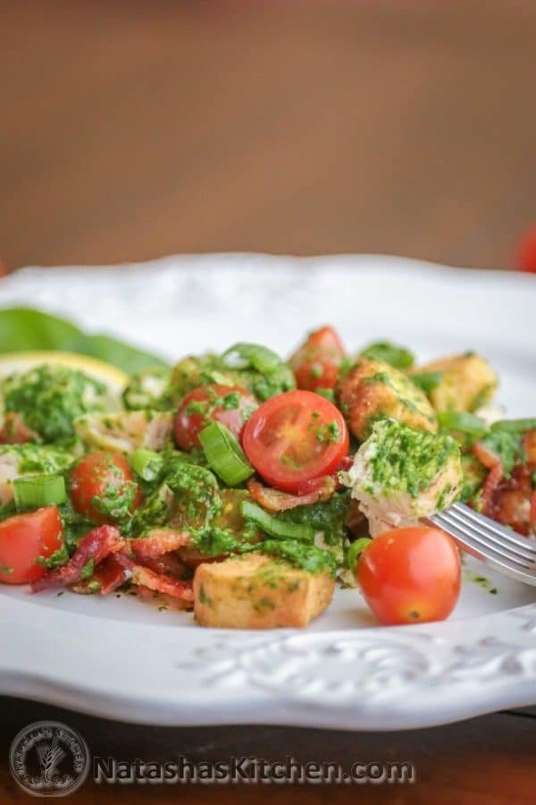 A plate with creamy spinach salad with chicken and baby tomatoes 