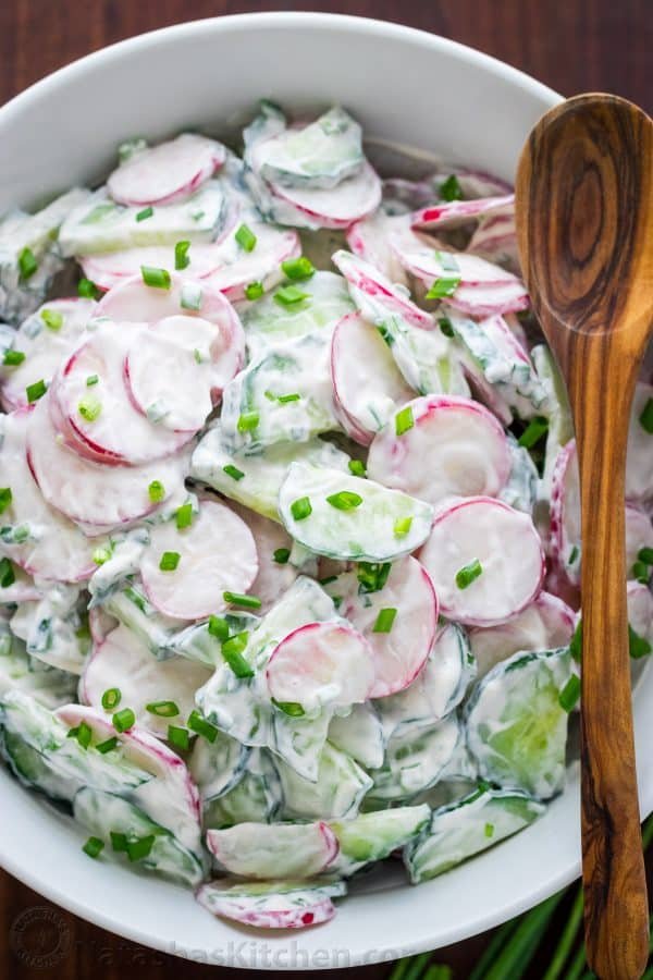 Radish Salad Recipe with Cucumbers and Creamy sour cream dressing plated with a mixing spoon