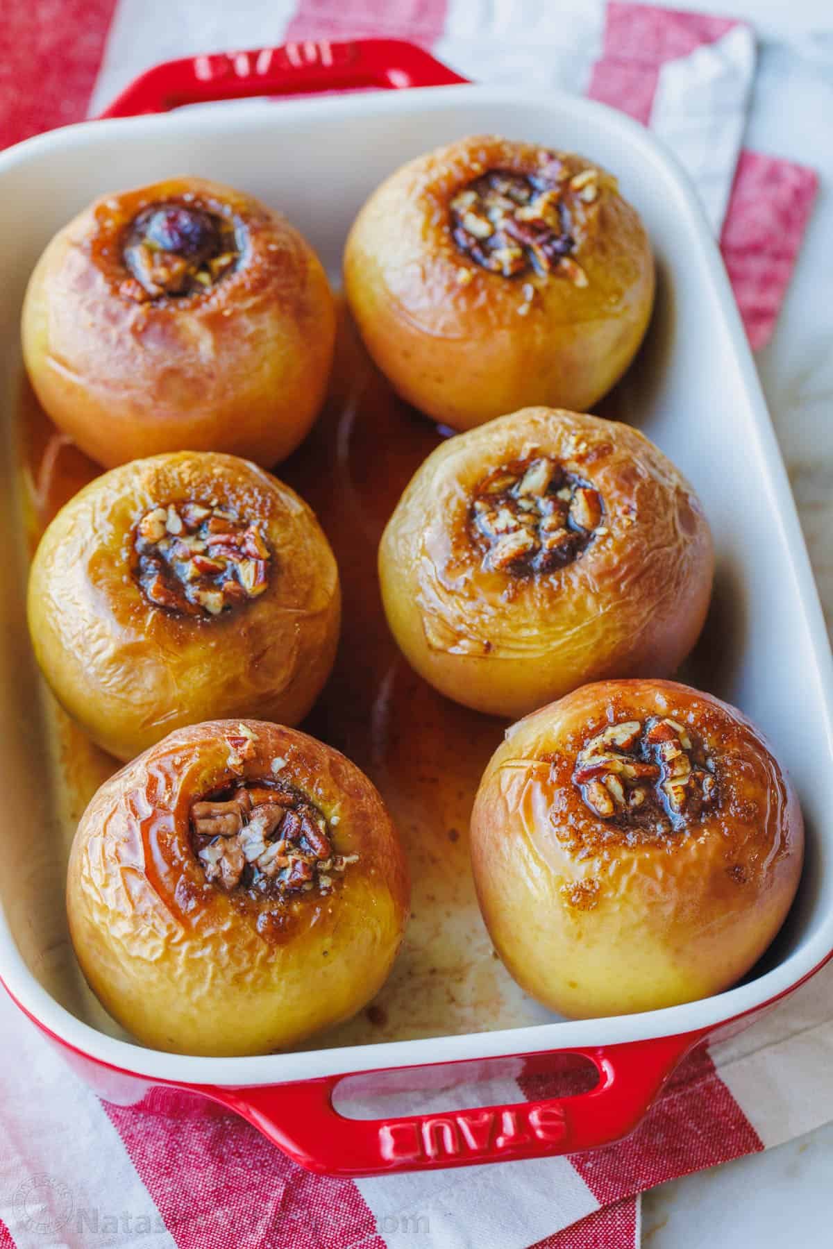These cozy Baked Apples are infused with fall flavor inside and out. Stuffed with cinnamon sugar, they taste just like apple pie filling! Baked apples filled with cinnamon sugar in a rectangular baking dish.