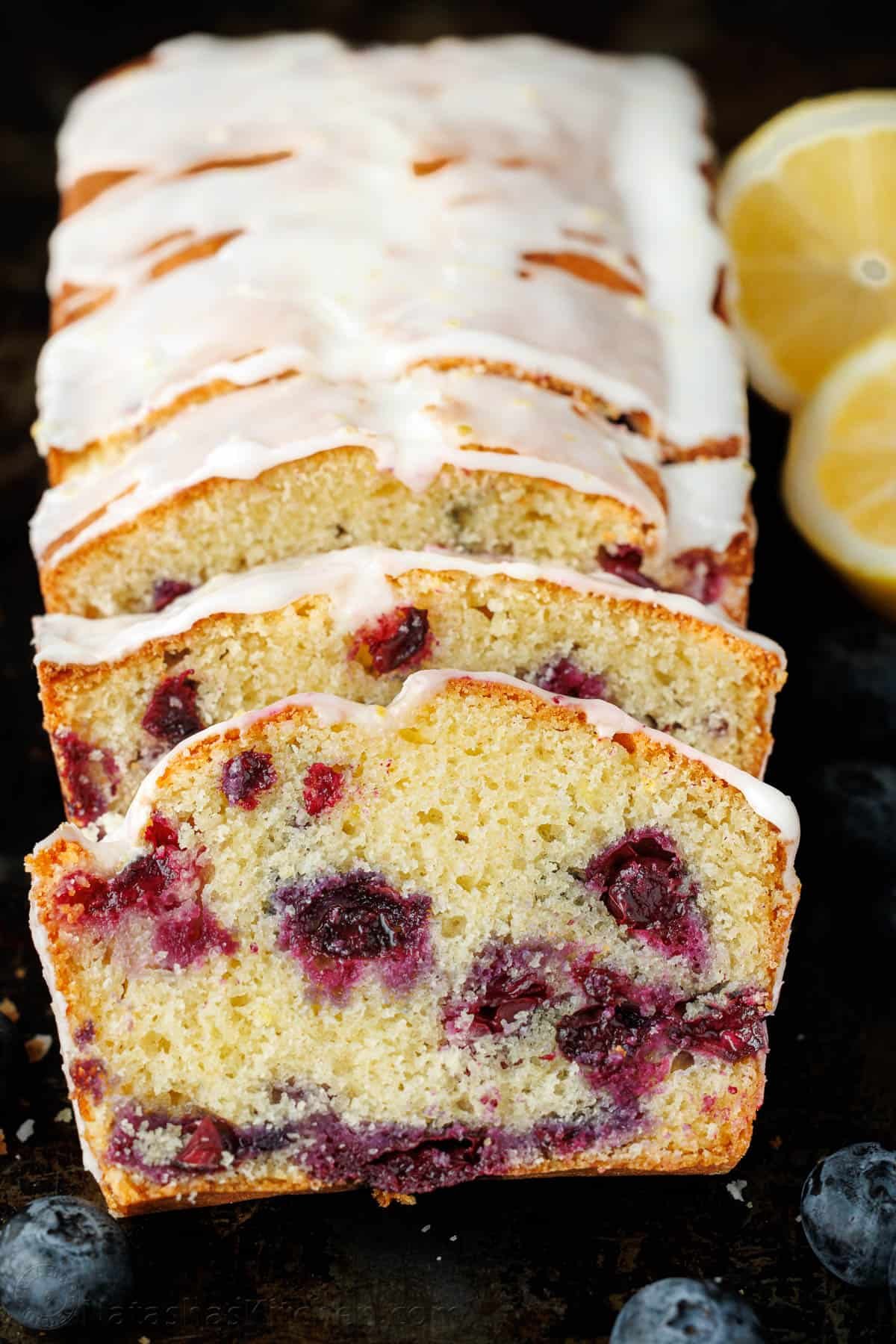 This Lemon Blueberry Bread has a moist and tender crumb and is loaded with blueberries. Don't skip the lemon glaze - you'll love every bite! Blueberry Lemon Bread sliced to showcase juicy blueberries cooked throughout each slice, drizzled with lemon glaze