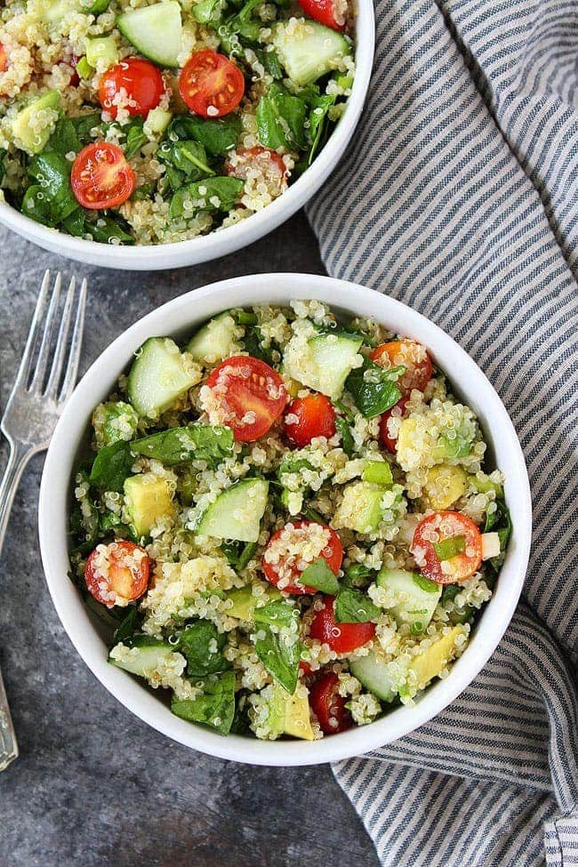 Easy Quinoa Salad is the BEST quinoa salad recipe! It is great for lunch, dinner, or the perfect side dish for potlucks and parties. #quionasalad #quinoa #salad #vegan #vegetarian #glutenfree #healthyrecipe #easyrecipe #veganrecipes #saladrecipe #salad Quinoa salad with spinach, cucumber, tomatoes, avocado, and green onion in bowl.
