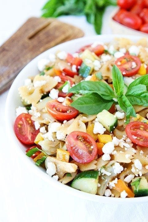 Easy Summer Pasta Salad Recipe Summer Pasta Salad with veggies in a bowl garnished with basil.