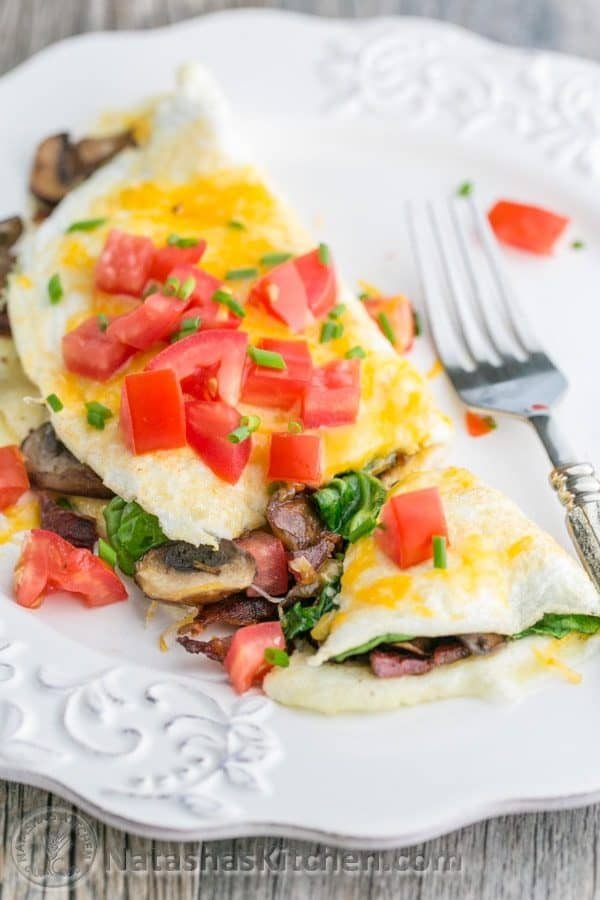 This fluffy egg white omelette is loaded with bacon, mushrooms, cheese, and fresh spinach which softens perfectly inside the omelette. So satisfying! | NatashasKitchen.com