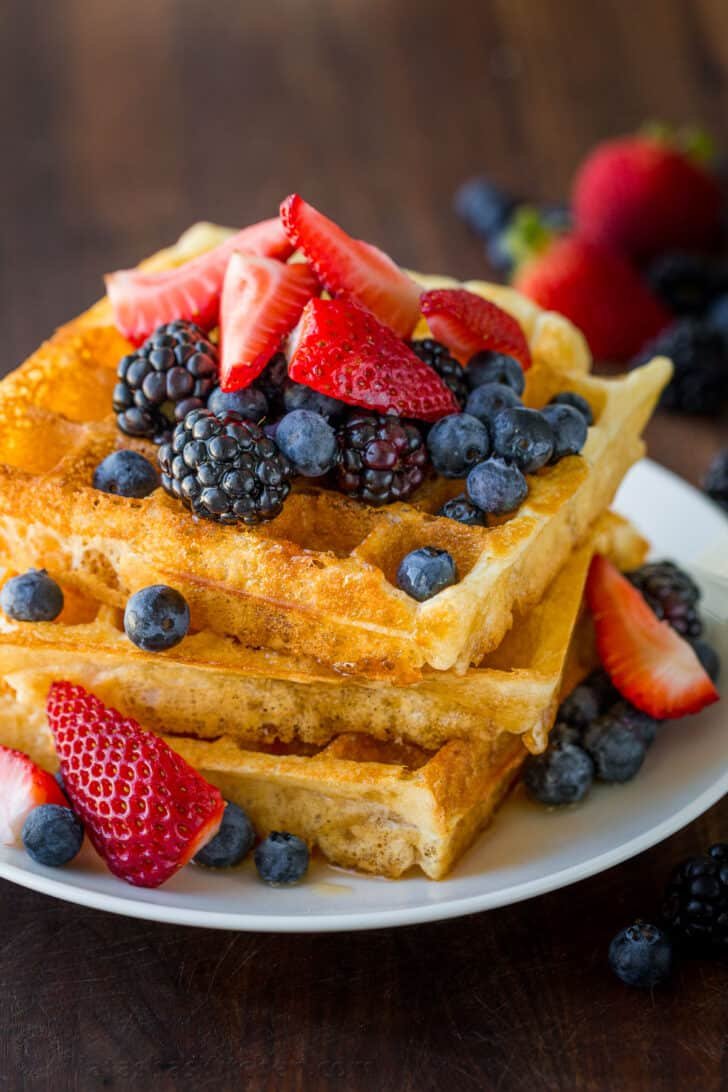 Homemade Waffle Recipe with the secret to super fluffy waffles! Perfect for sweet or savory waffles, and American or Belgian waffle makers. Stack of waffles with berries