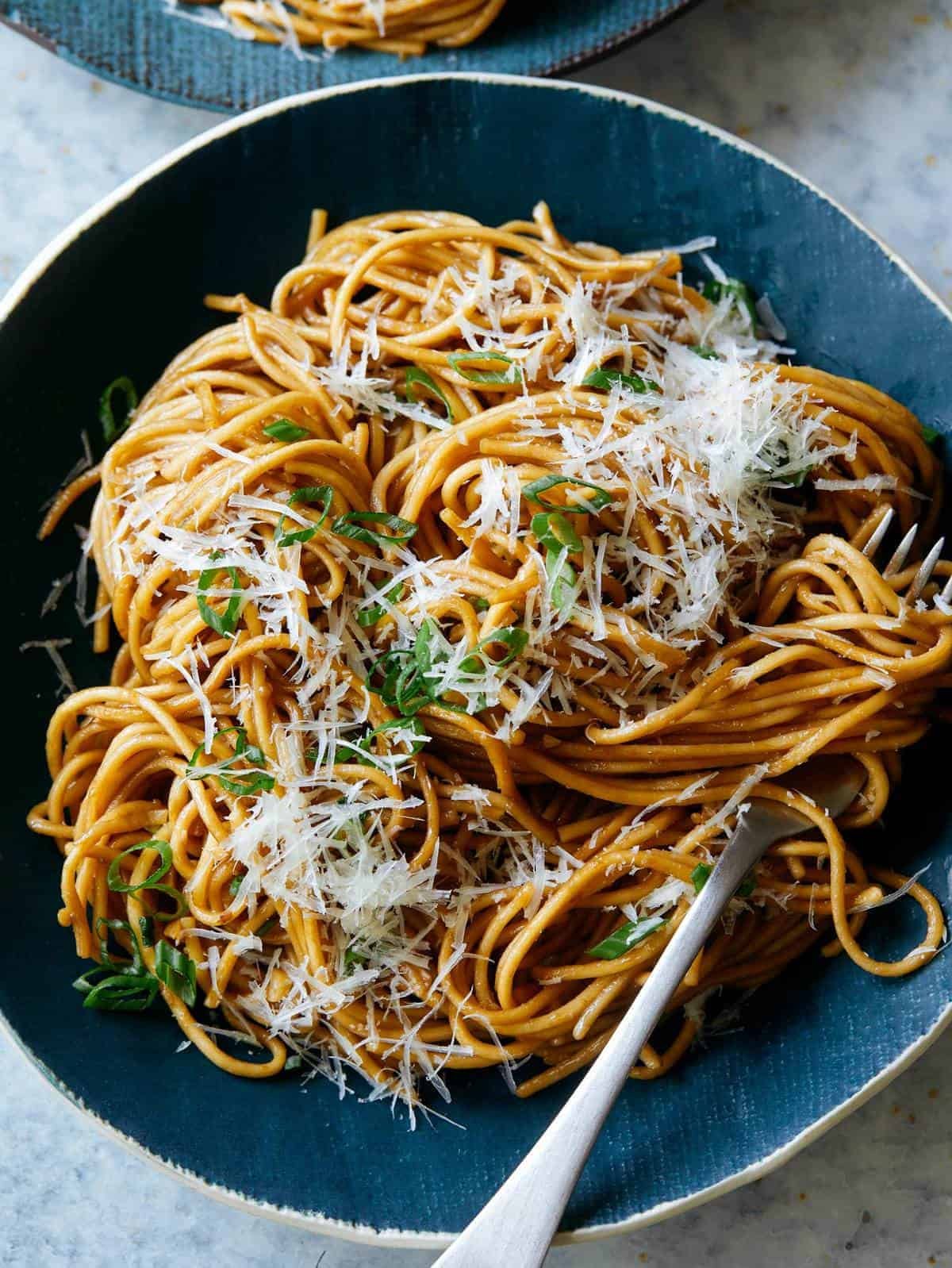 bowl of finished garlic noodles with fork nestled in the noodles