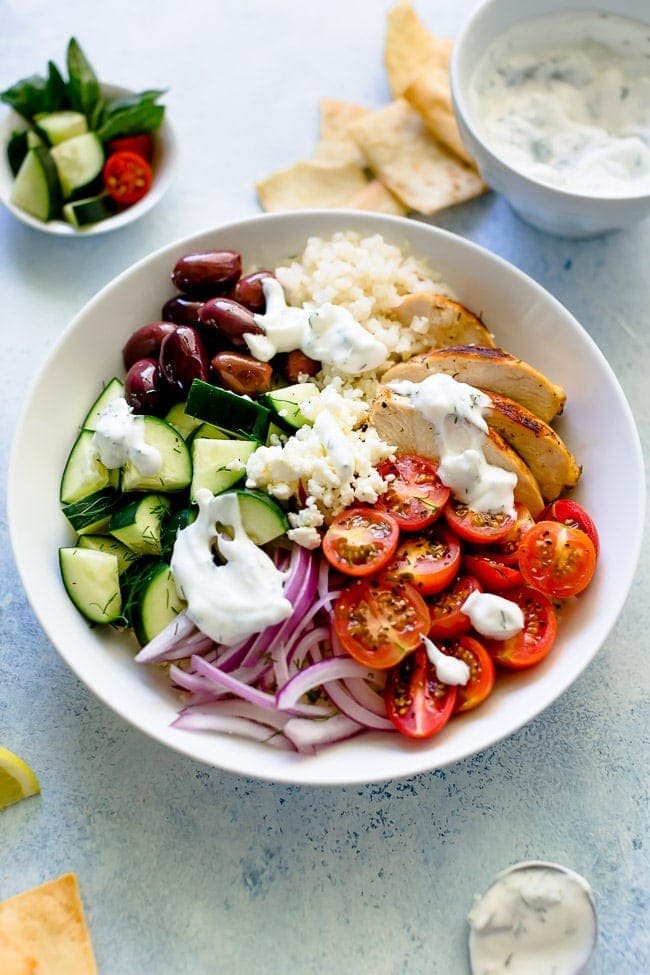 Greek Chicken Bowls Are Made With Lemon Oregano Chicken, Rice, Tomatoes, Cucumber, Olives, Feta Cheese, Red Onion, Fresh Herbs, And Finished With Tzatziki Sauce. These Healthy Bowls Are Great For Lunch Or Dinner. #chicken #chickendinner #dinner #bowls #Greek #healthyrecipe #chickenrecipe #rice #easyrecipe #mealprep Greek Chicken Bowls Recipe