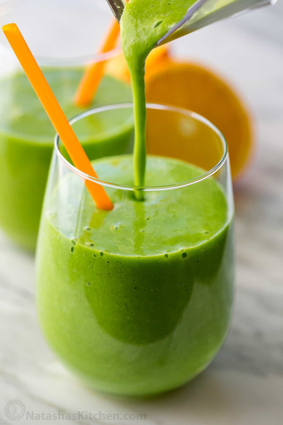 This Green Smoothie recipe is packed with nutritious ingredients like spinach, orange, pineapple, banana, and chia seeds. It's so refreshing. Our favorite Green Smoothie in glass with a straw.