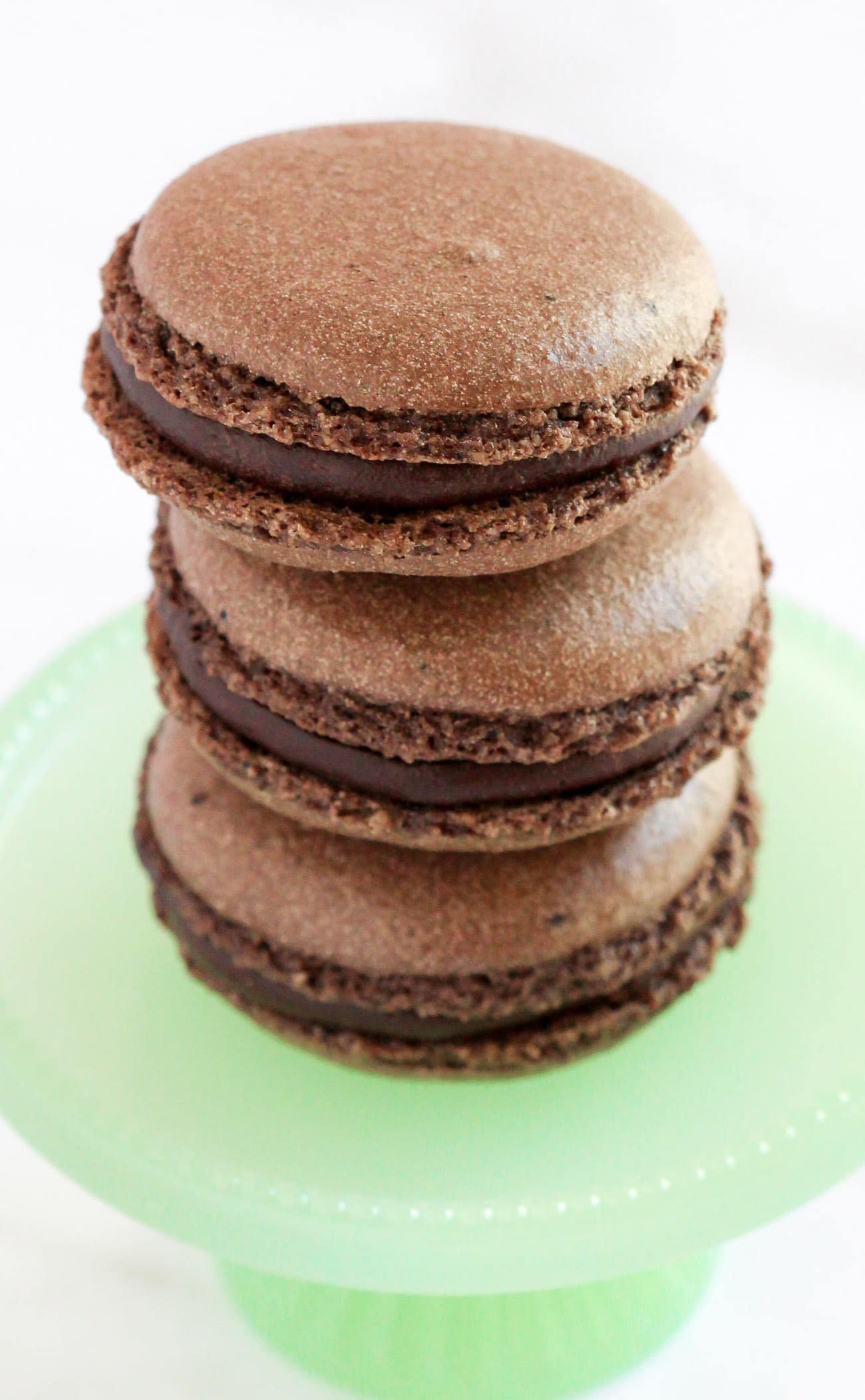 These Gluten Free Chocolate French Macarons are perfectly sweet and chewy, thanks to the almond meal and dark cocoa powder! Made without the bleached white sugar and artificial flavors, yet you'd never know! #chocolate #frenchmacarons #macarons #glutenfree #glutenfreemacarons #valentinesday