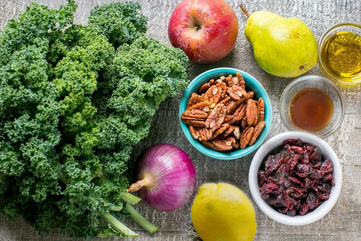 You will love this Autumn-inspired Kale Salad Recipe with apples, pears, cranberries, and toasted pecans with honey lemon dressing. It's so easy to prepare and it's one of the few green salads that can be made ahead. #kalesalad #kalesaladrecipe #kalesaladdressing #salad #saladrecipes Kale Salad Ingredients