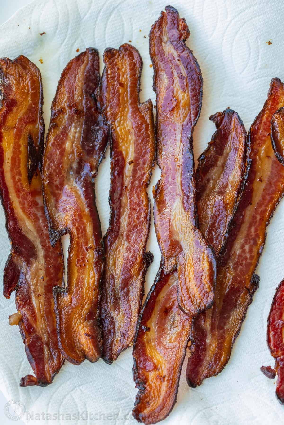 How to bake bacon in the oven that is perfectly crispy. Oven-baked bacon is the best for making a bigger batch and it's the easiest method. Stripped cooked after learning how to bake bacon