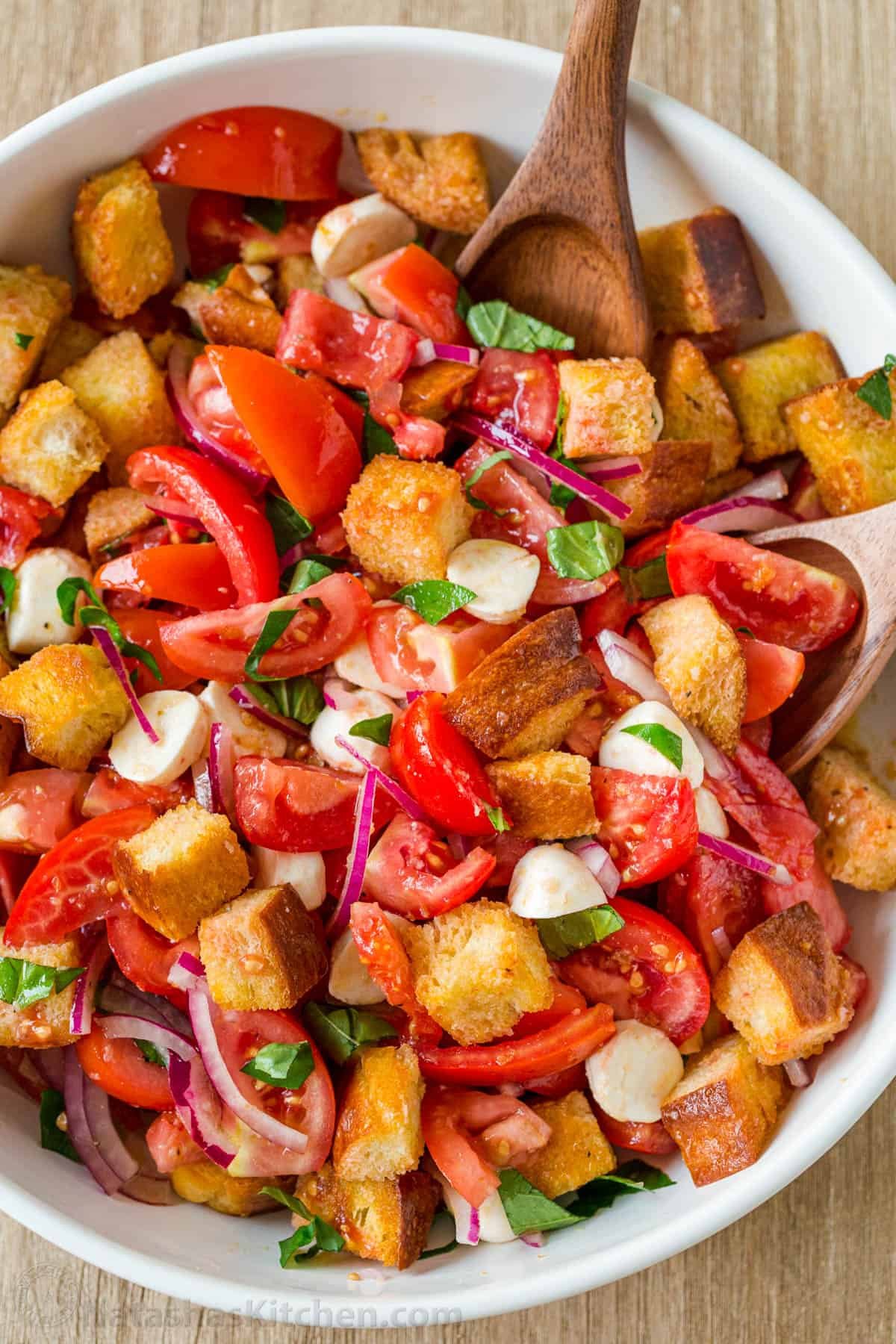 Panzanella Salad tossed in a bowl garnished with basil