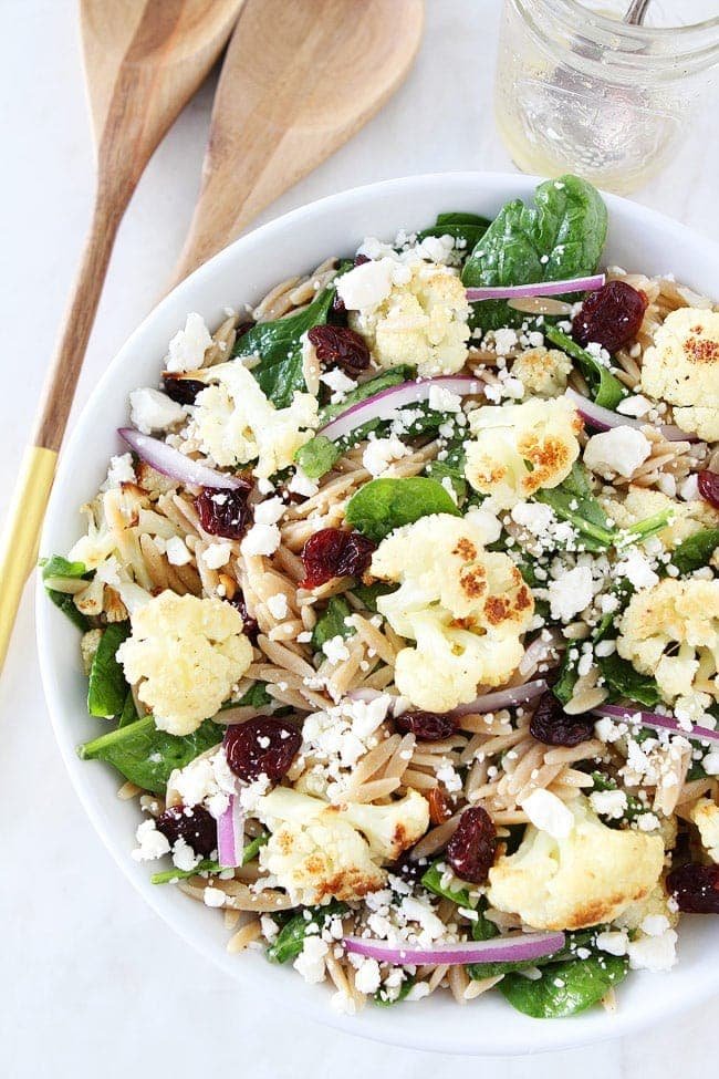 Roasted Cauliflower, Feta, and Orzo Salad Recipe on twopeasandtheirpod.com Spinach salad with roasted cauliflower, orzo, feta cheese, dried cherries, red onion, and a simple honey lemon dressing. This salad is great for lunch or dinner. Roasted Cauliflower, Feta, and Orzo Salad Recipe