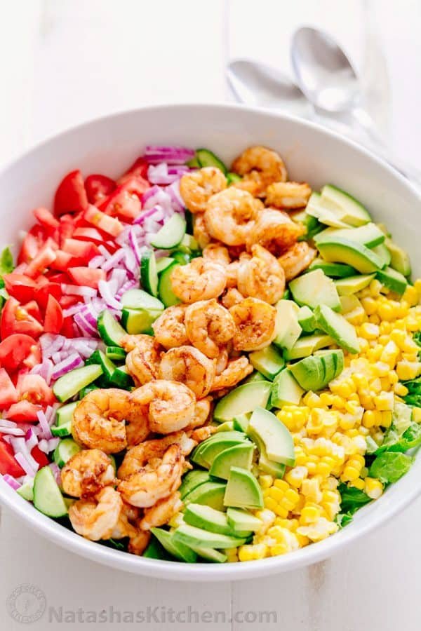 We could live off this shrimp avocado salad. It's crazy good and loaded with avocado, cucumbers, tomatoes, sweet corn and tossed with a light and easy cilantro-lemon dressing. This shrimp salad has all the best flavors of summer! WINNER!! | natashaskitchen.com