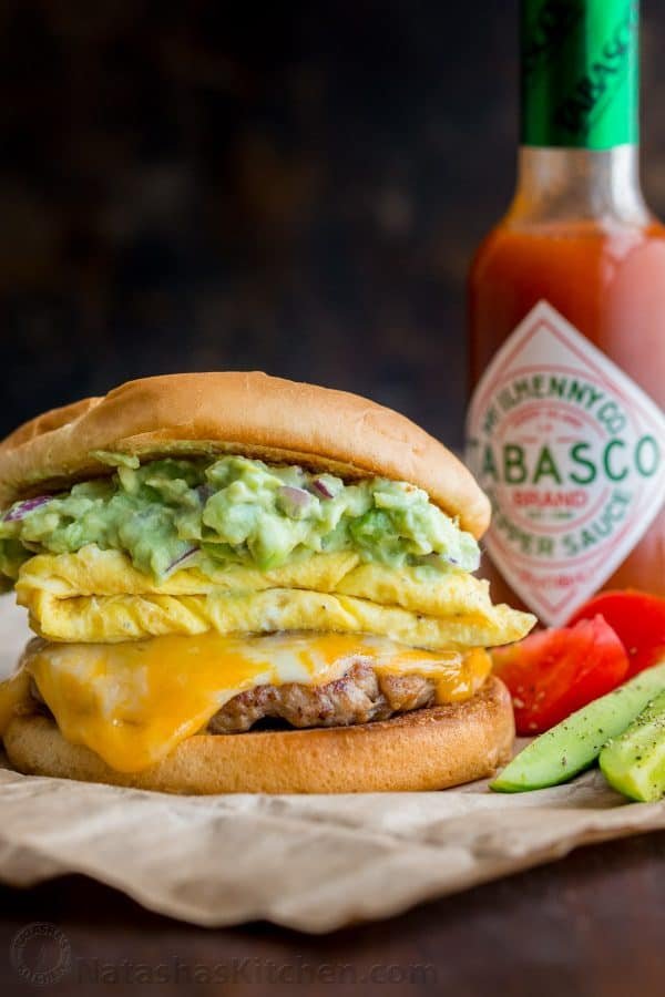 Spicy guacamole brunch sandwich with a crisp toasted bun, juicy sausage, melty cheese, fluffy eggs and guacamole! Easy guacamole breakfast sandwich! | natashaskitchen.com
