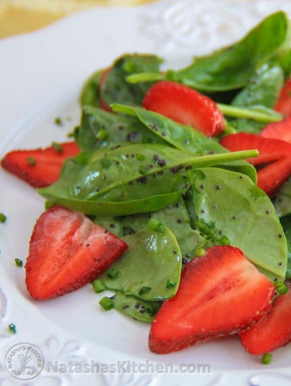 Spinach strawberry salad on a white plate 