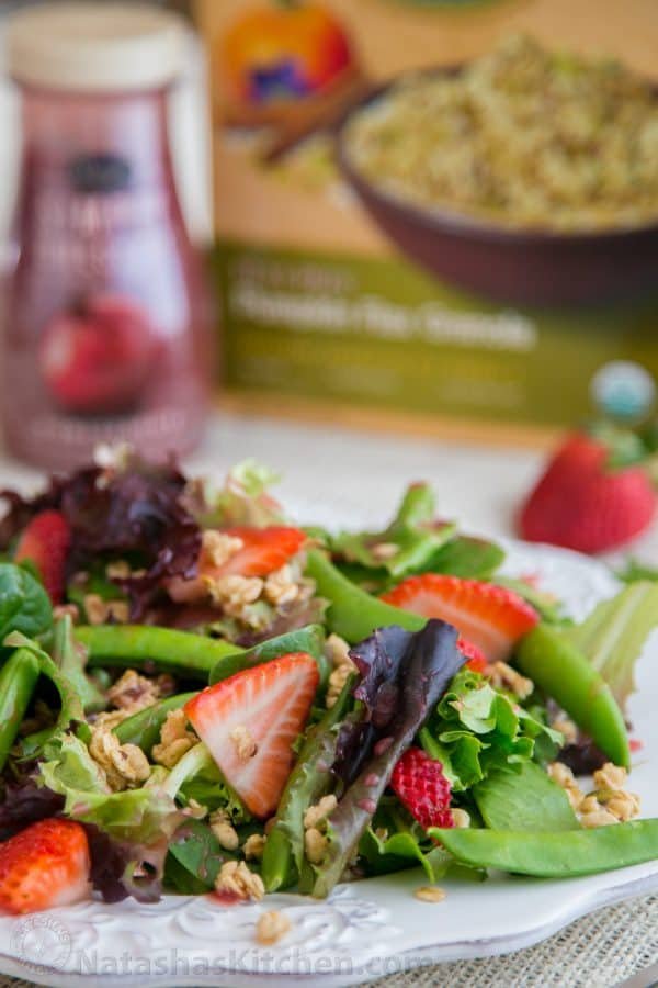 A plate of strawberry, snap pea and mixed green salad