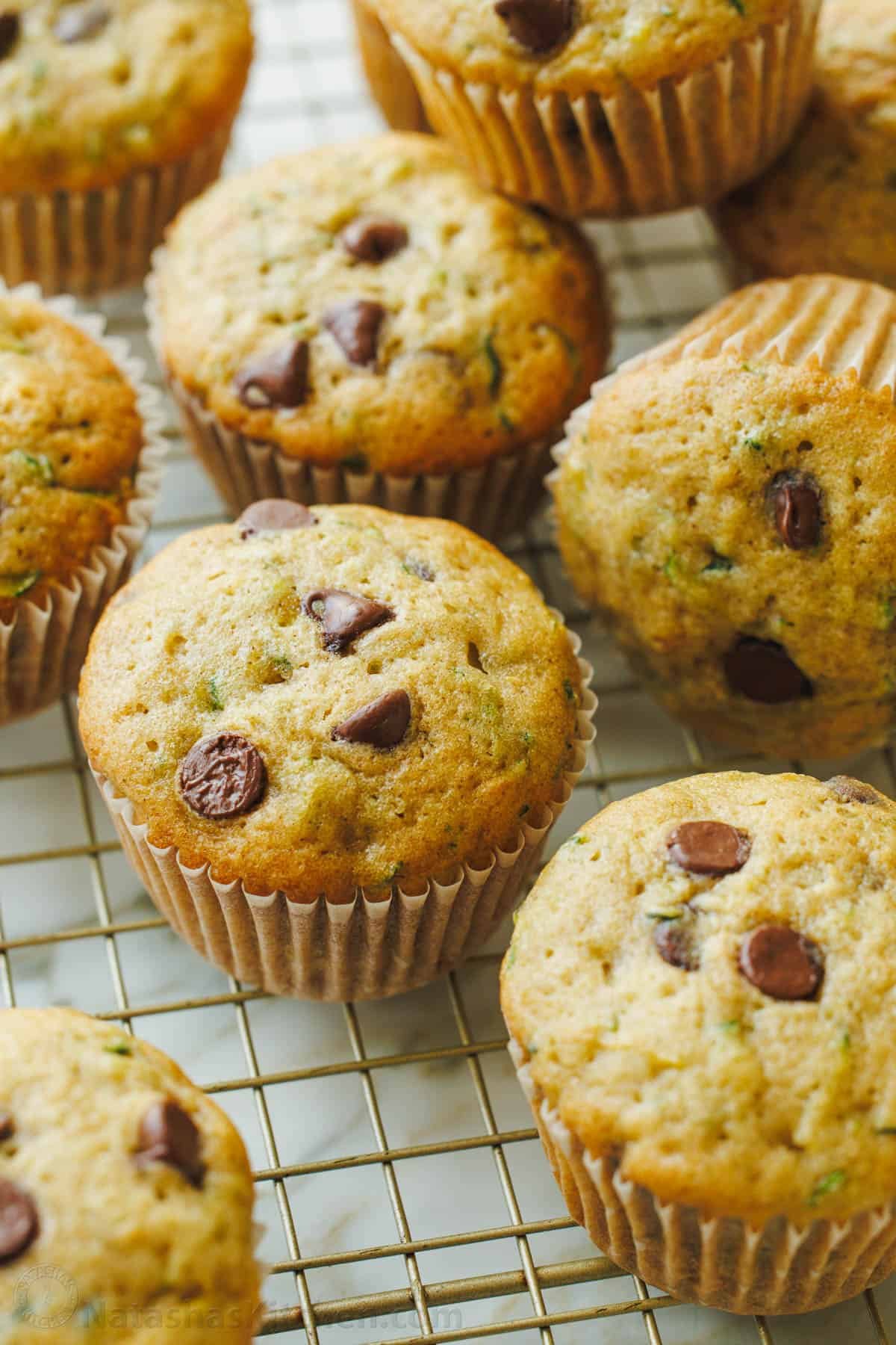 golden zucchini muffins cooling on a rack