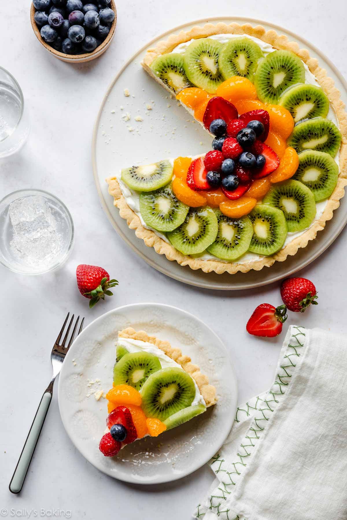 fresh fruit tart with slice taken out and on plate.