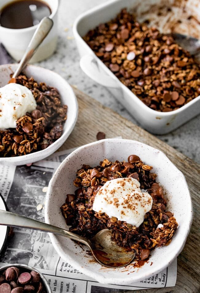 chocolate zucchini baked oatmeal in bowl with whipped cream. 