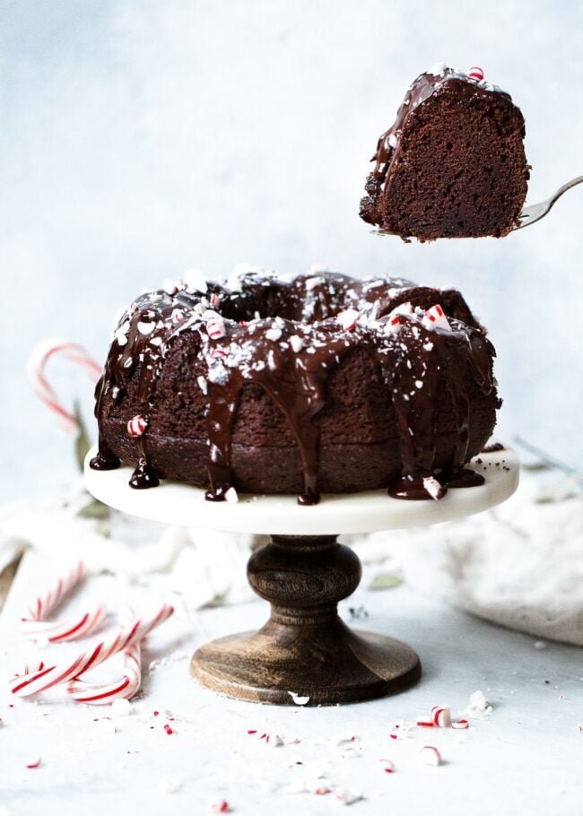 a piece of cake being cut out of a chocolate peppermint bundt cake. 
