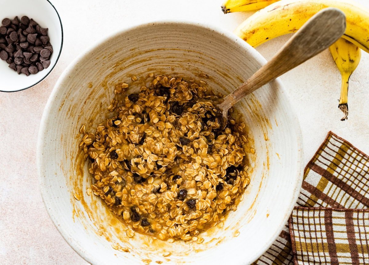 peanut butter banana oatmeal bar mixture in mixing bowl with spoon. 