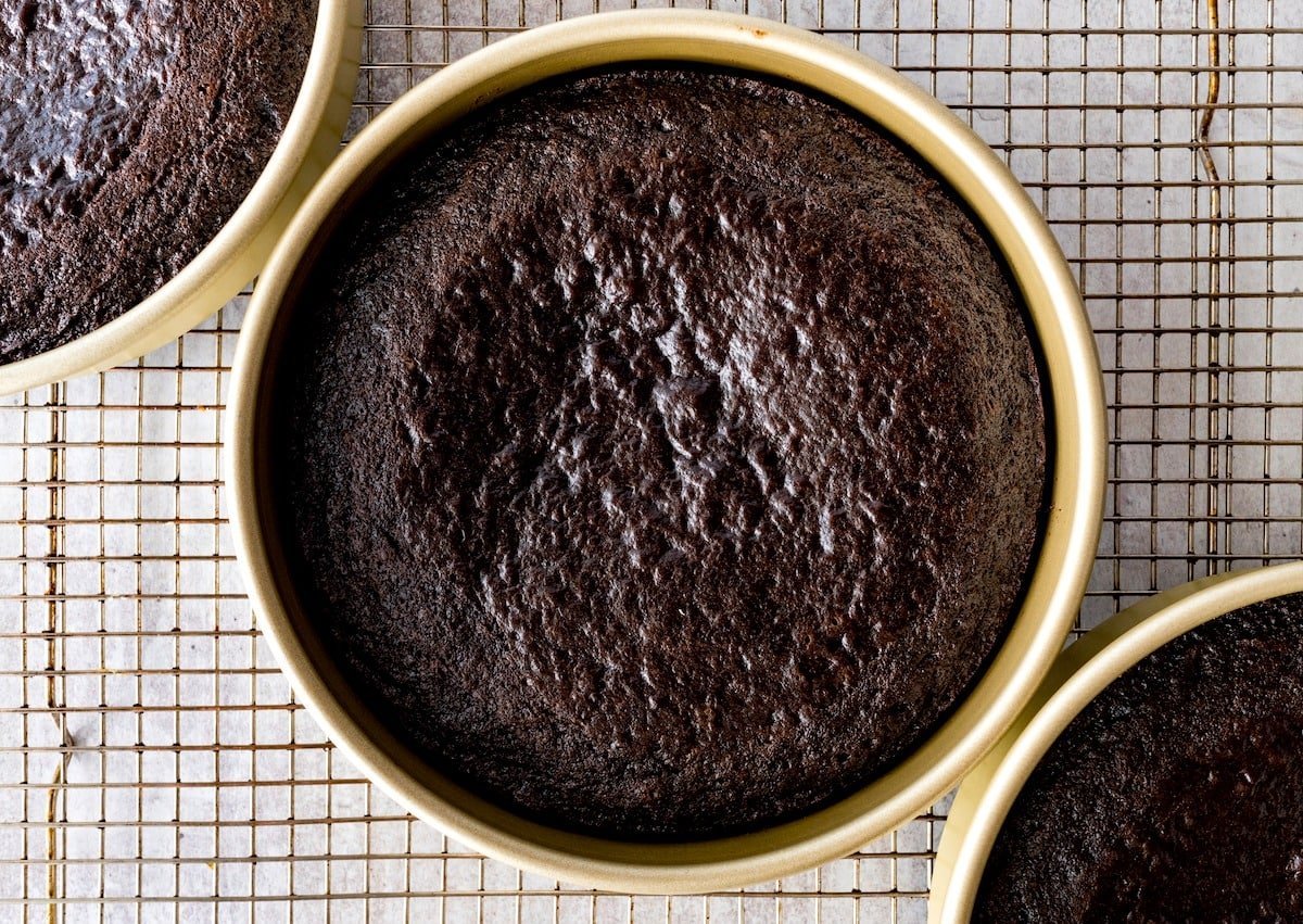 chocolate cake in cake pans on cooling rack. 