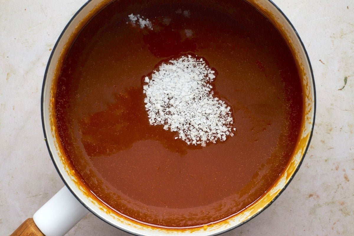salted caramel sauce in pot with sea salt. 