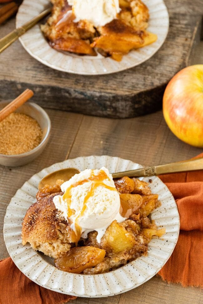 apple cobbler with ice cream in bowl with salted caramel sauce.
