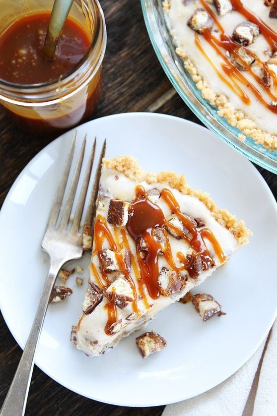 Twix Ice Cream Pie Recipe on twopeasandtheirpod.com Shortbread cookie crust with a layer of chocolate, vanilla ice cream, chopped Twix candy bars, and salted caramel sauce. This ice cream pie is AMAZING! Twix Ice Cream Pie with caramel sauce