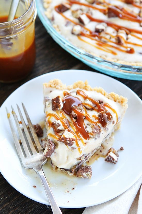 Twix Ice Cream Pie Recipe on twopeasandtheirpod.com Shortbread cookie crust with a layer of chocolate, vanilla ice cream, chopped Twix candy bars, and salted caramel sauce. A MUST make summer dessert! Twix Ice Cream Pie on plate
