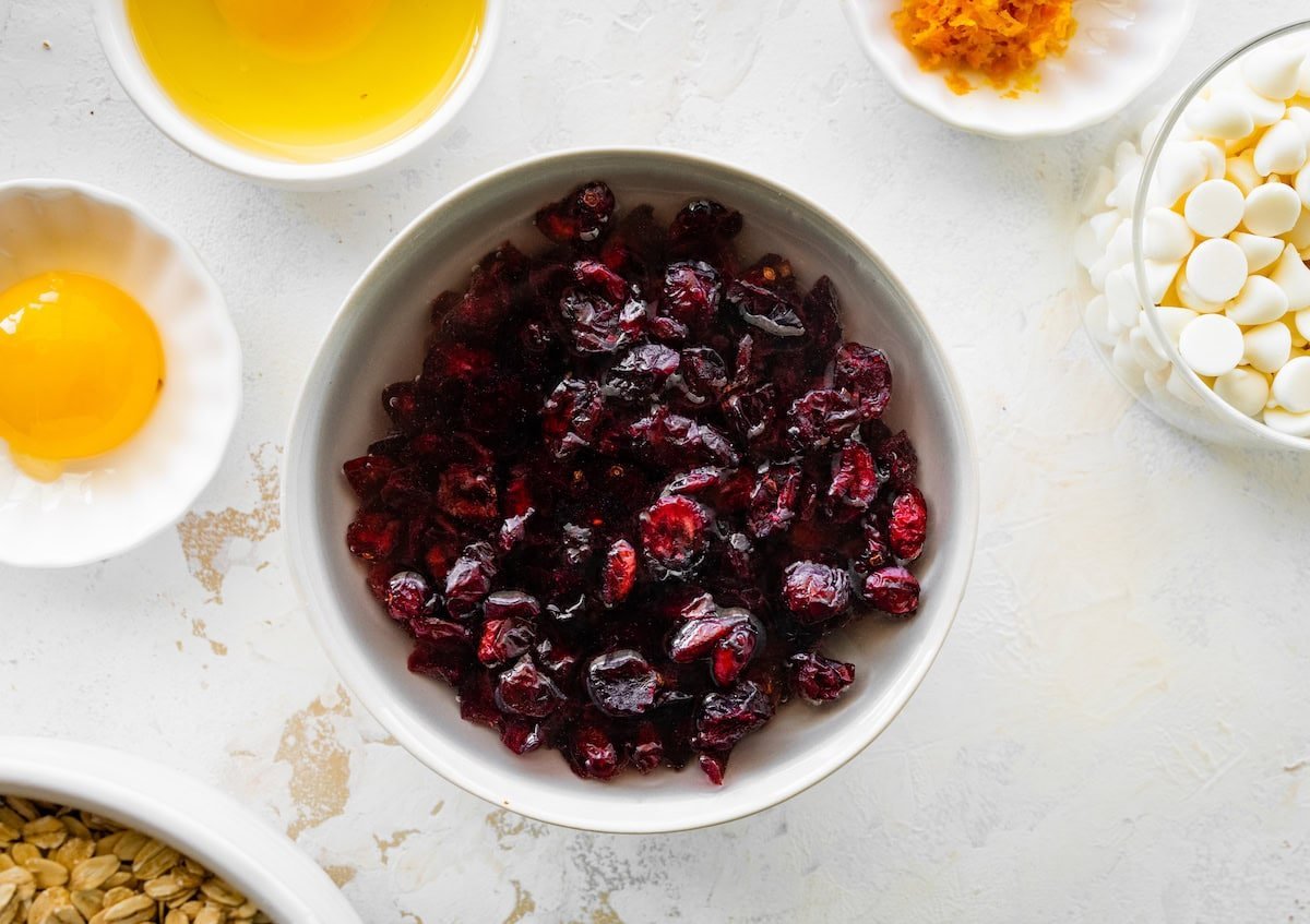 dried cranberries soaking in a bowl of hot water.