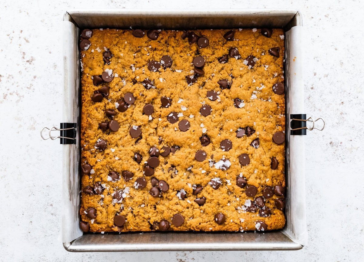 flourless peanut butter blondies with flaky sea salt in pan.