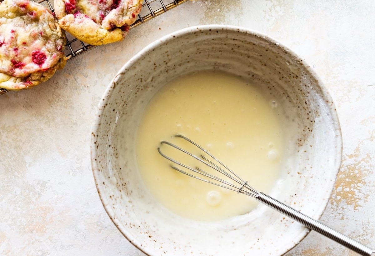 lemon glaze in bowl with whisk.