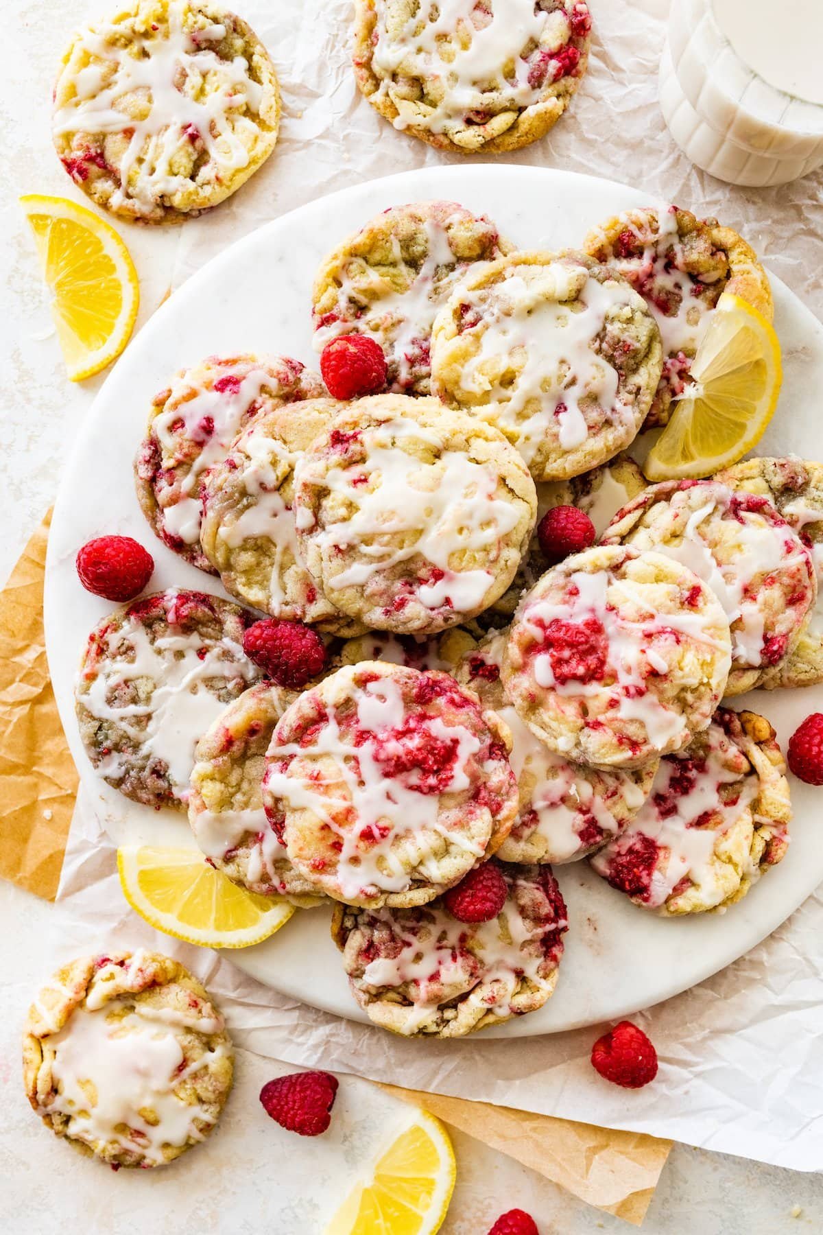 lemon raspberry cookies with lemon glaze on white platter.
