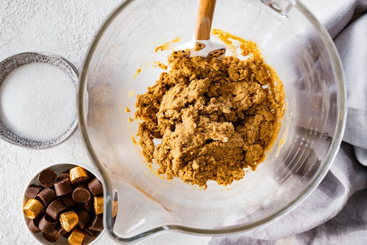 ginger molasses cookie dough in mixing bowl with spatula.