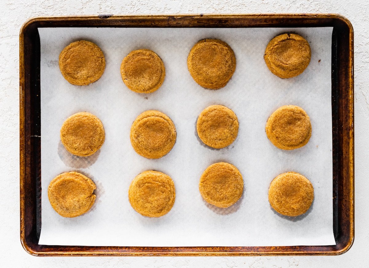 ginger molasses rolo cookies on baking sheet with parchment paper.