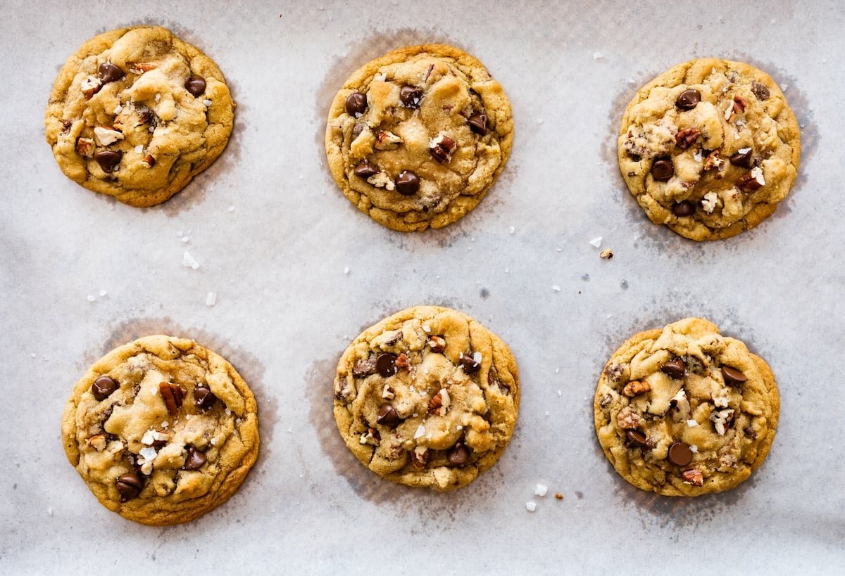 maple pecan chocolate chip cookies on parchment paper lined baking sheet.