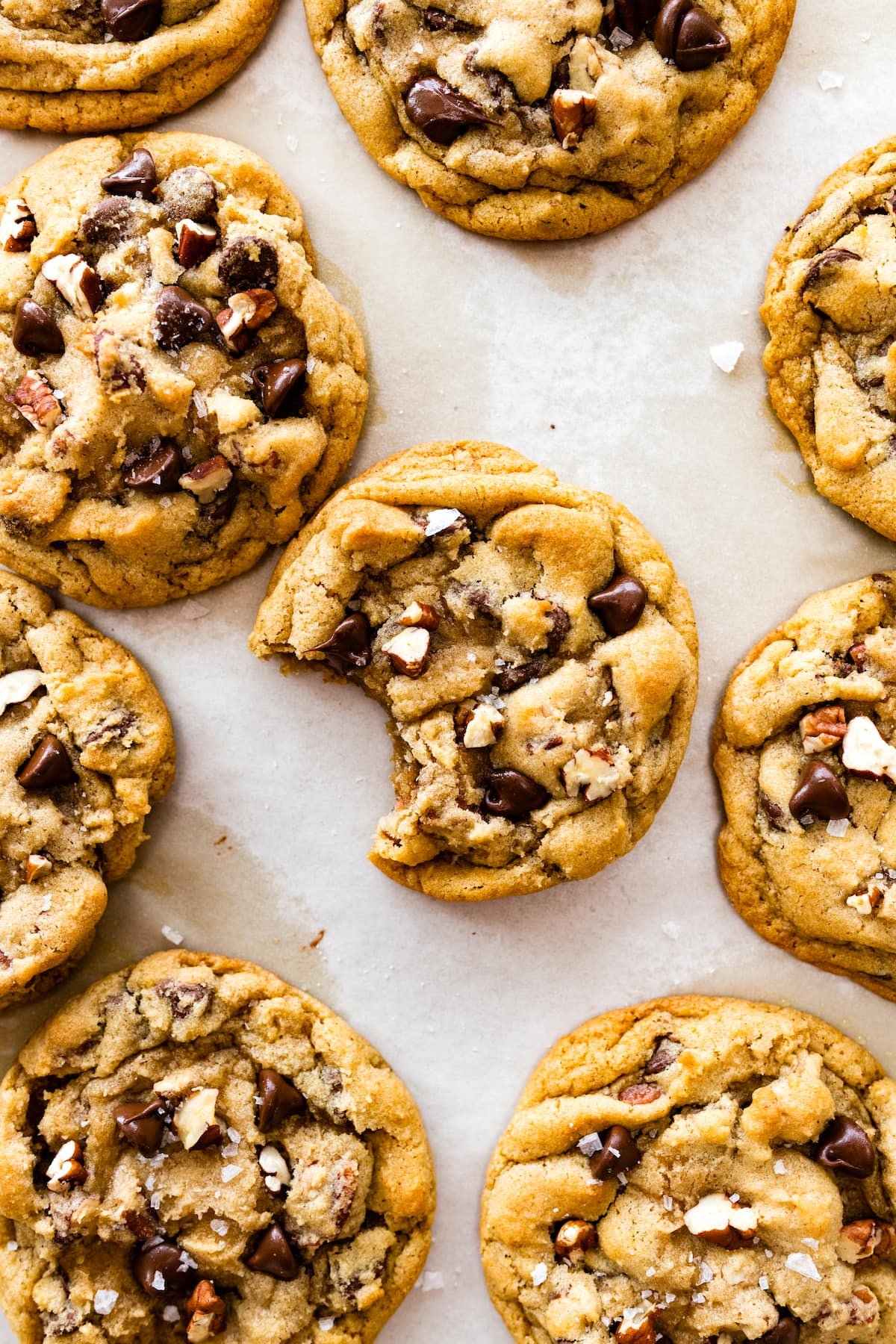 maple pecan chocolate chip cookies with one cookie that has a bite out of it.