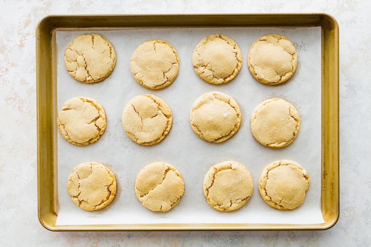 brown butter sugar cookies on baking sheet with parchment paper.