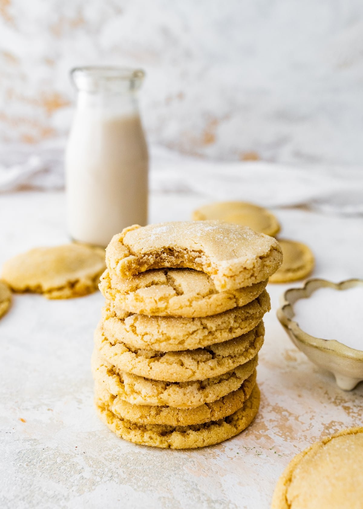 stack of brown butter sugar cookies with bottle of milk.