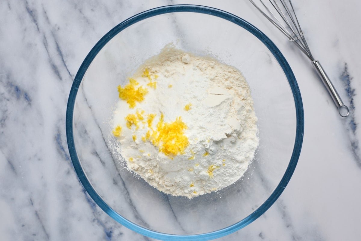 flour, baking powder, baking soda, salt, sugar, and lemon zest in glass bowl with whisk.