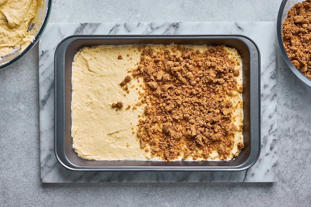 sour cream coffee cake batter in pan with cinnamon streusel topping.