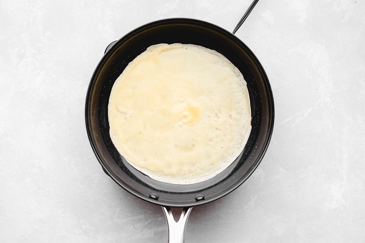 crepe cooking in a skillet.
