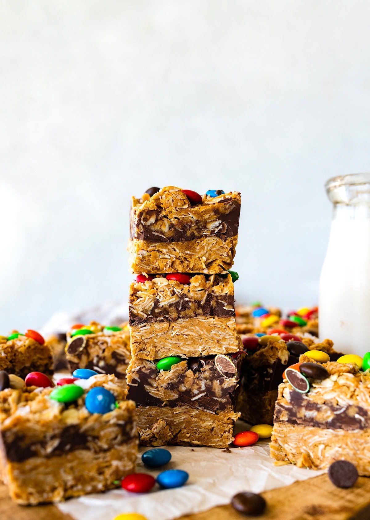 no bake monster cookie bars stacked with bottle of milk.