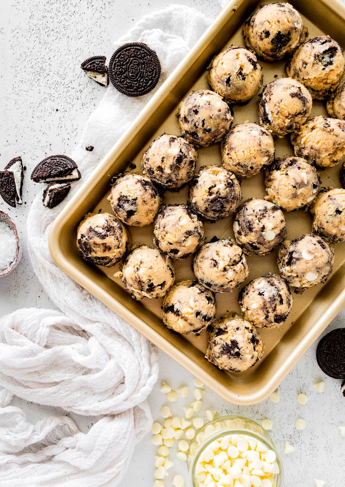 cookies and cream cookie dough balls on baking sheet.