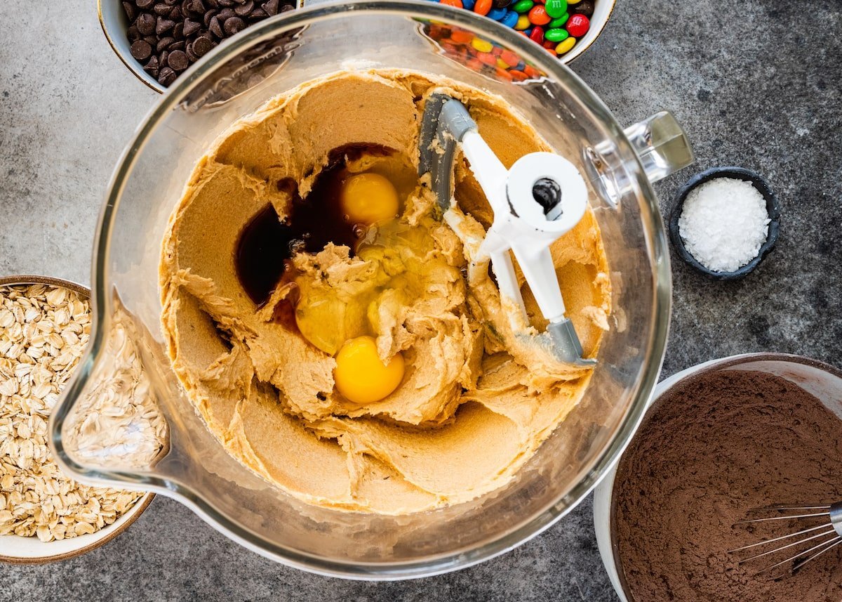 butter, sugars, vanilla, and eggs in mixing bowl to make chocolate monster cookies.