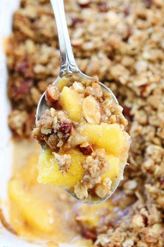 Peach Almond Crisp Recipe on twopeasandtheirpod.com Simple crisp made with fresh peaches and an almond oat topping. Peach Crisp in a pan